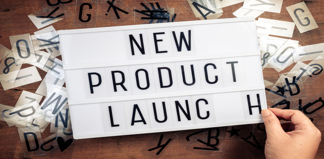 A lightbox contains the words "new product launch," with each word on a different line. A hand applies the h to the word launch.